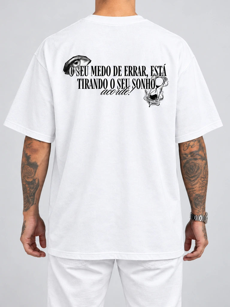 Cor: Branco | Costas | Oversized — Camiseta Seu Medo de Errar Está Tirando o Seu Sonho, Acorde (Verso)